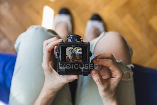 Visão superior de uma menina tira uma foto com sua câmera de formato médio. — Fotografia de Stock