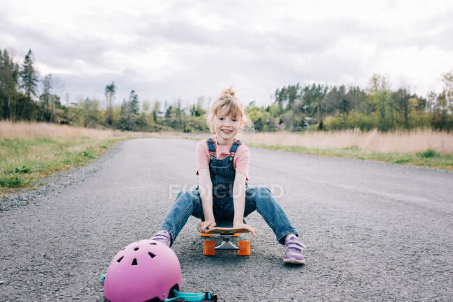 Молода дівчина вчиться скейтборді самостійно — стокове фото