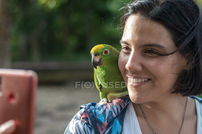 Woman performs a selfie with a parrot in the jungle of the Orinoco Delta in Venezuela — Stock Photo