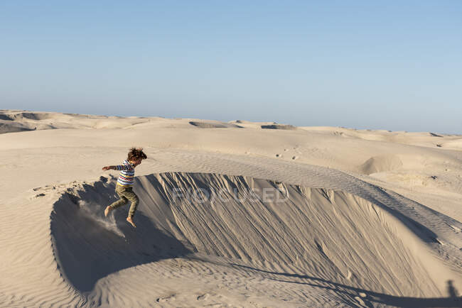 Un bambino che salta da una duna di sabbia a Dunas de la Soledad — Foto stock