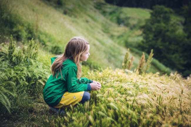 Little girl in green field in mountains — Stock Photo
