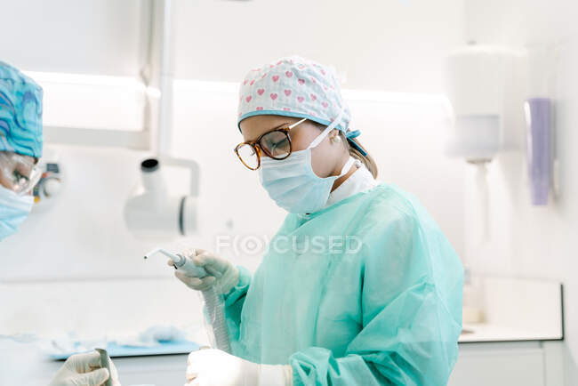 Asistente de dentista prepara a un paciente para una operación - foto de stock