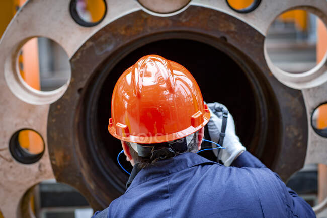 Offshore operator inspects pipe and flange before instal — Stock Photo