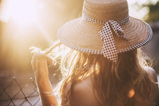 Visão traseira da mulher loira com chapéu de palha no pôr do sol — Fotografia de Stock