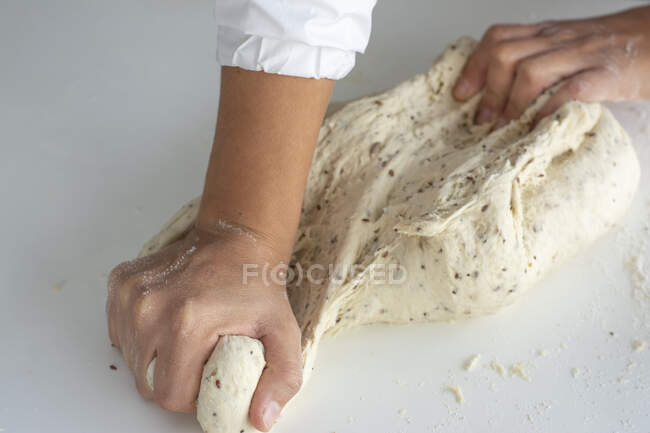 Hombre amasando una masa grande para pan casero en cuarentena - foto de stock