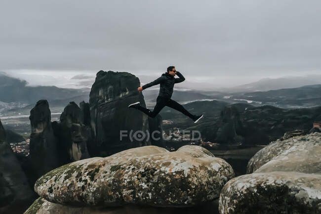Excited Silhouette Man Jumping Against Foggy Weather in the mountains — Stock Photo