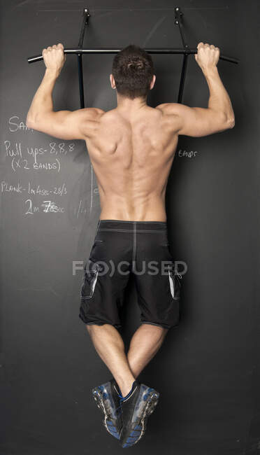 Homme en forme avec faire pull ups dans la salle de gym — Photo de stock