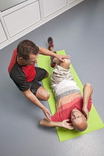 Personal trainer helping client in gym — Stock Photo