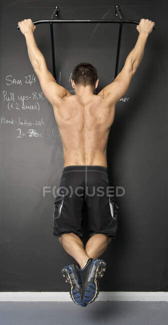 Fit man with doing pull ups in gym — Stock Photo