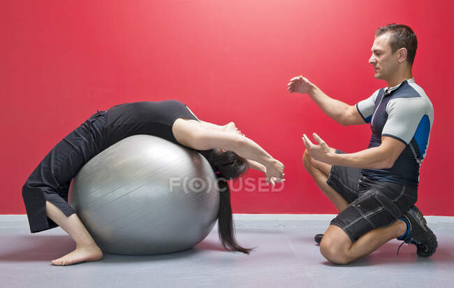 Personal Trainer hilft Klient im Fitnessstudio — Stockfoto