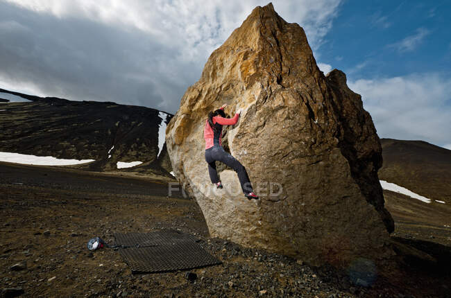 Frau bouldert auf Felsen im ländlichen Island — Stockfoto
