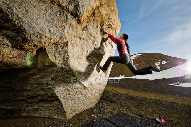 Mujer que bouldering en roca en rural Islandia - foto de stock