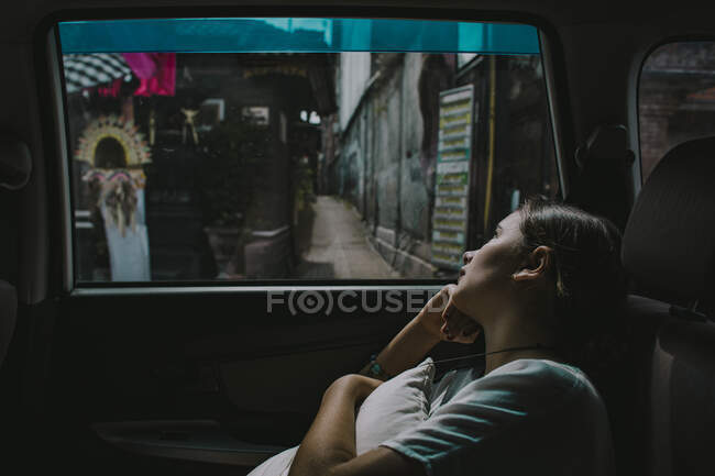 A young girl looks out of the window of a car in Seminyak Bali — Stock Photo