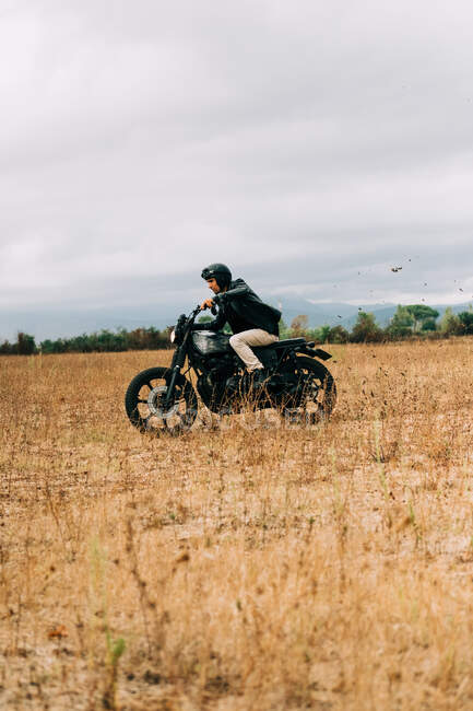 Hombres montando una moto en el campo de Italia - foto de stock