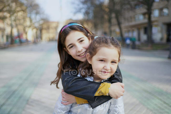 Dos chicas felices miran a la cámara con una sonrisa - foto de stock