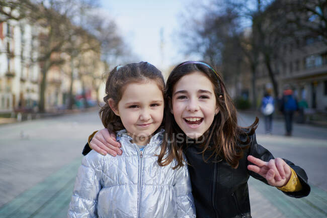 Zwei glückliche Mädchen blicken lächelnd in die Kamera — Stockfoto