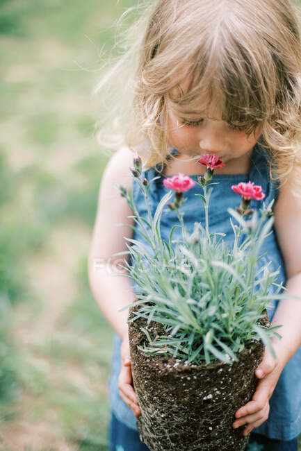 Little girl with  pink flowers in garden — Stock Photo