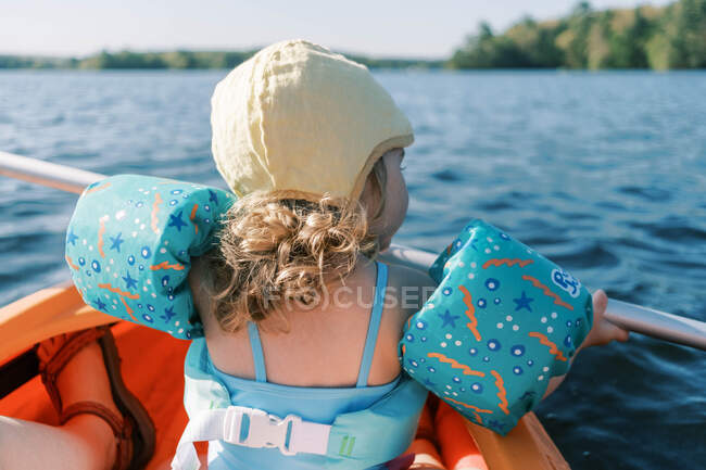 Little girl trying to paddle in a kayak. — Stock Photo