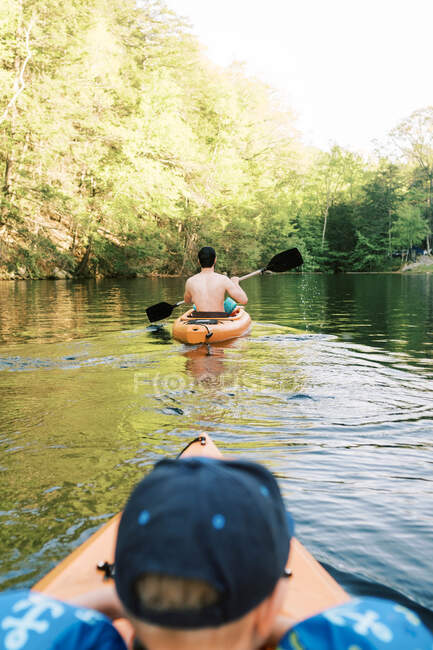 A family enjoying a sunny summer day at the lake in their kayaks — Stock Photo
