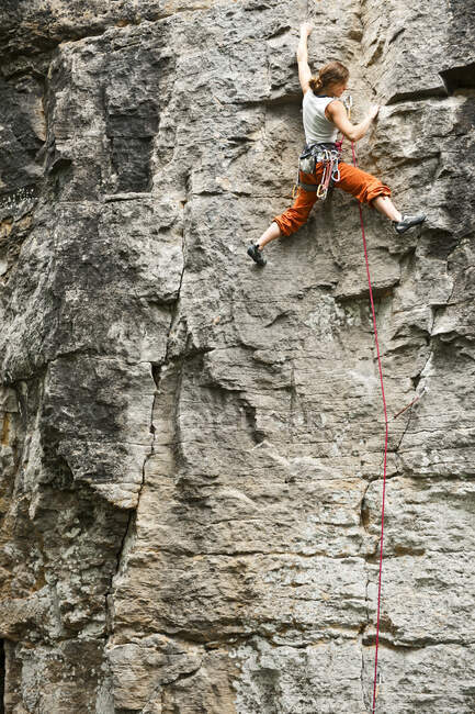 Jeune femme escalade face rocheuse en France — Photo de stock