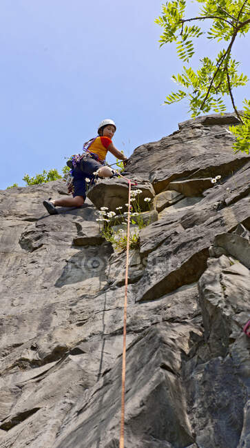 Mujer escalando acantilado de piedra caliza en Gales del Sur - foto de stock