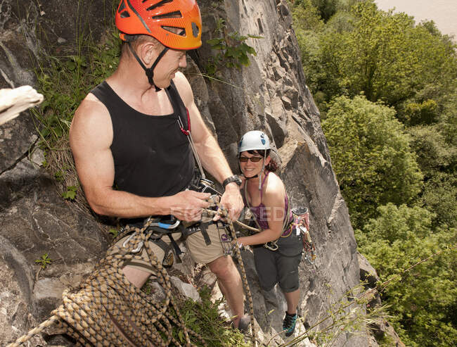 Casal escalada íngreme rosto de rocha no sul do País de Gales — Fotografia de Stock