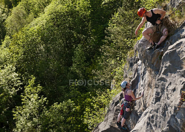 Pareja escalando empinada cara de roca en el sur de Gales - foto de stock