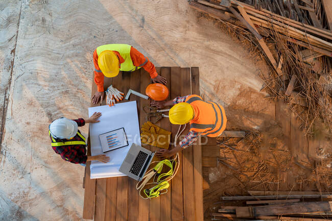 Luftaufnahme einer Gruppe asiatischer Ingenieure oder Architekten und Bauarbeiter auf der Baustelle. — Stockfoto