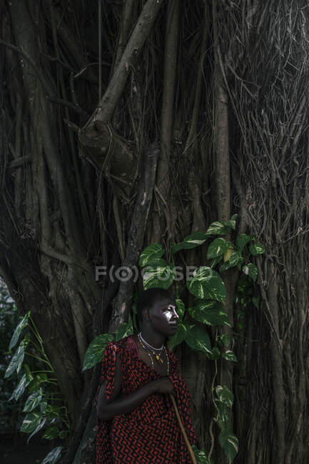 Maasai Man em roupas tradicionais em pé na floresta — Fotografia de Stock