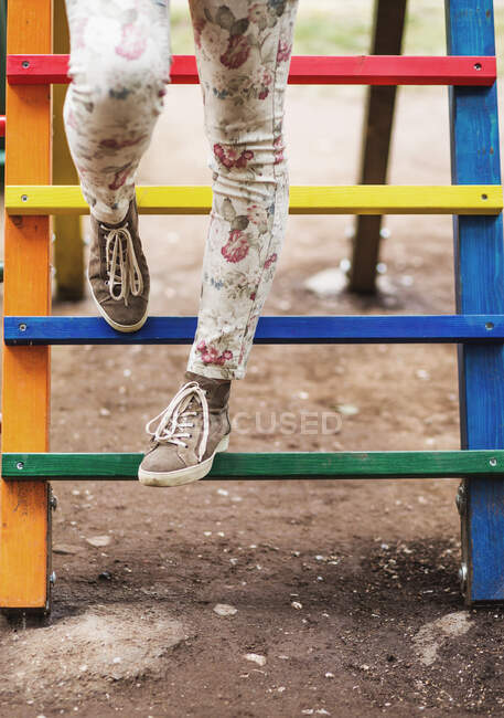Jambes de femme dans l'aire de jeux colorée pour enfants — Photo de stock