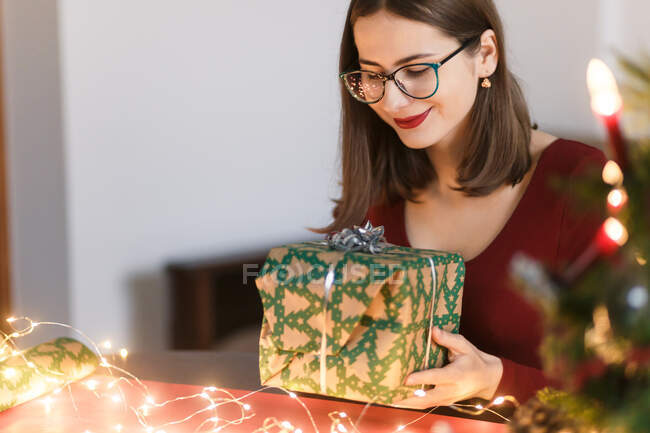 Jeune femme millénaire avec cadeaux de Noël dans une ambiance festive — Photo de stock