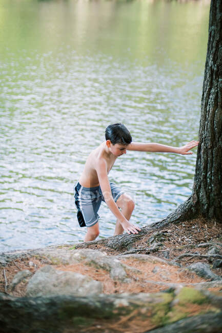 Niño caminando en la orilla después de un baño en el lago - foto de stock
