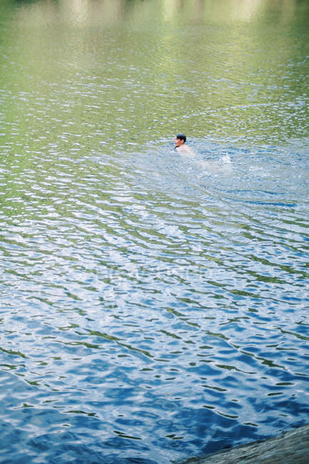 Um menino nadando em um lago. — Fotografia de Stock