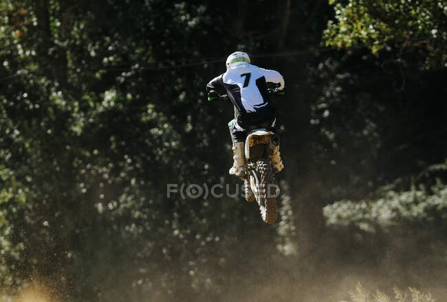 Motocross numero 7 che salta con polvere — Foto stock