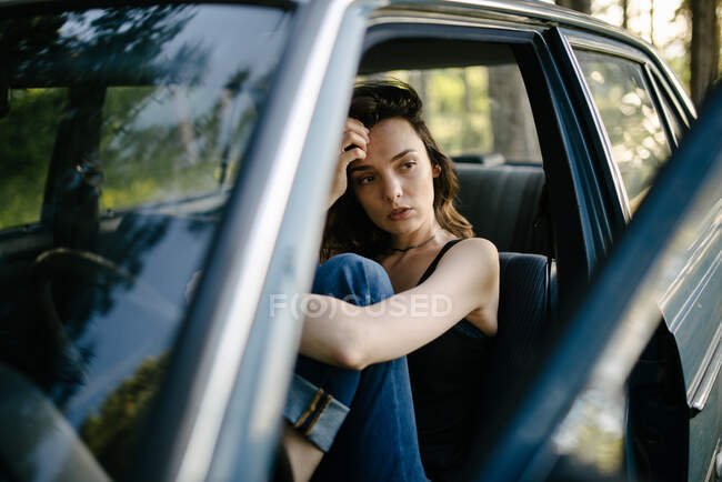 Jovem hipster mulher olhando na floresta de carro vintage — Fotografia de Stock