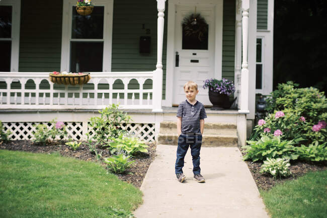 Un bambino di cinque anni in posa per un ritratto davanti alla sua porta — Foto stock