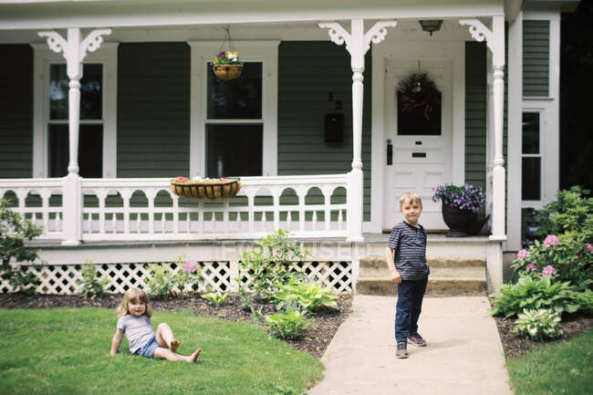 Deux enfants devant leur maison — Photo de stock