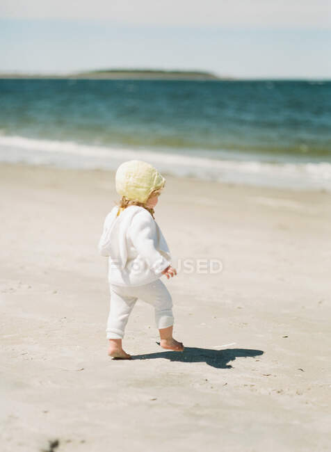 A toddler girl playing in the sand at the beach — Stock Photo