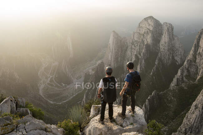 Два друга, стоящие на скале у скалы в Нидо-де-Агилучос — стоковое фото