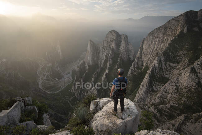 Jovem escalando montanhas rochosas — Fotografia de Stock