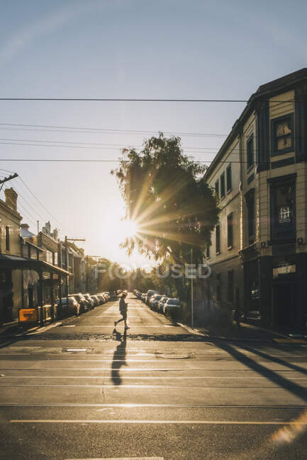 Junge Frau überquert Straße, während sie telefoniert, Melbourne, Australien — Stockfoto