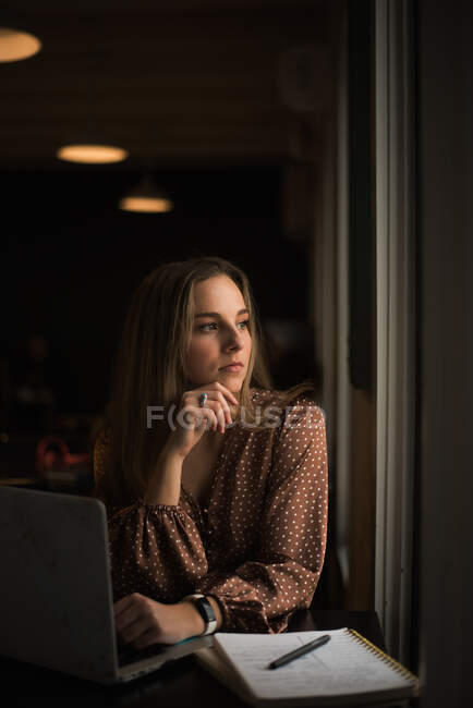 Joven blogger influencer trabajando en una cafetería junto a una ventana 2 - foto de stock
