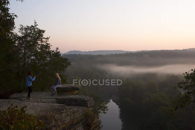 Meninas tirando fotos na montanha com vista para o nascer do sol — Fotografia de Stock