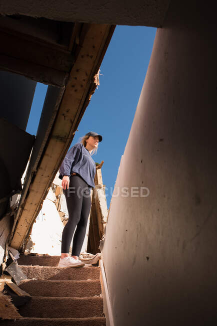Chica de pie en la destrucción de tornado - foto de stock