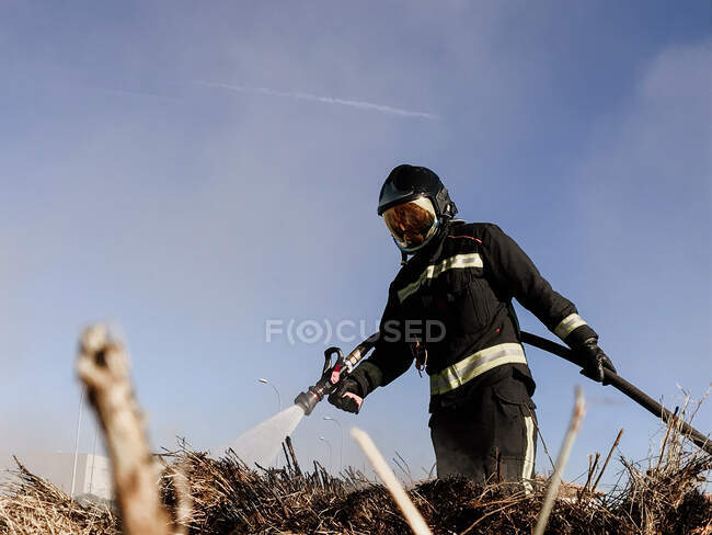 Feuerwehrleute versprühen Wasser für Flächenbrand. — Stockfoto