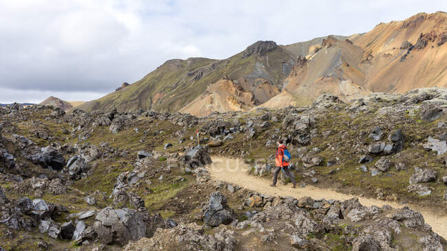 Young man hiking down the rocky trail in Landmannalaugar — Stock Photo