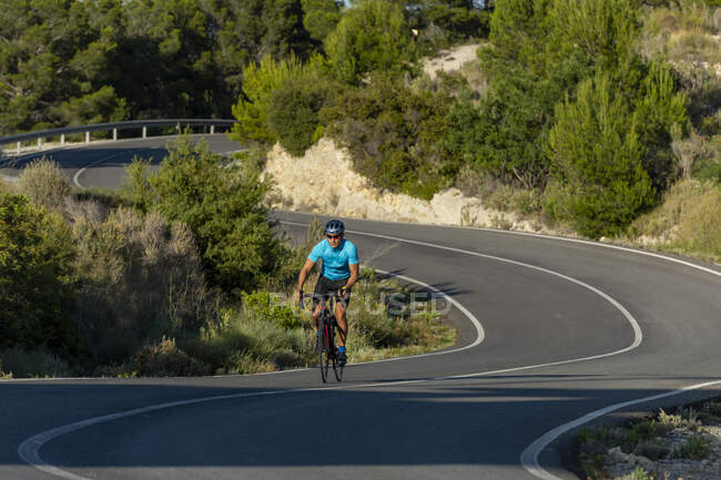 Ciclista em colinas perto da aldeia de Relleu, Alicante, Costa Blanca, Espanha — Fotografia de Stock