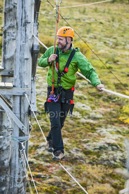 Homem balanceando em curso de obstáculo de corda alta na Islândia — Fotografia de Stock