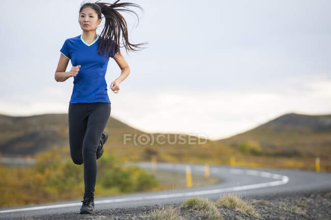 Schöne Frau joggt in ländlicher Gegend in Island — Stockfoto
