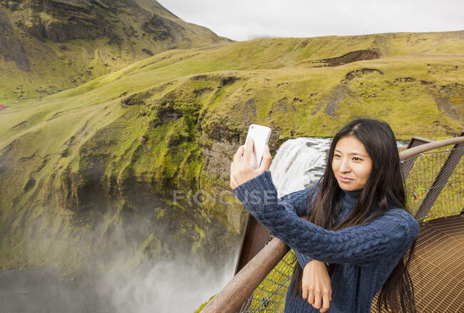 Красивая женщина делает селфи на водопаде Скогарфосс в Исландии — стоковое фото